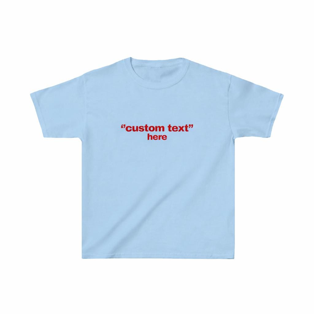 May include: Light blue t-shirt with short sleeves. The shirt features the red text "custom text" above the word "here". The shirt is made of a soft material and is suitable for casual wear.