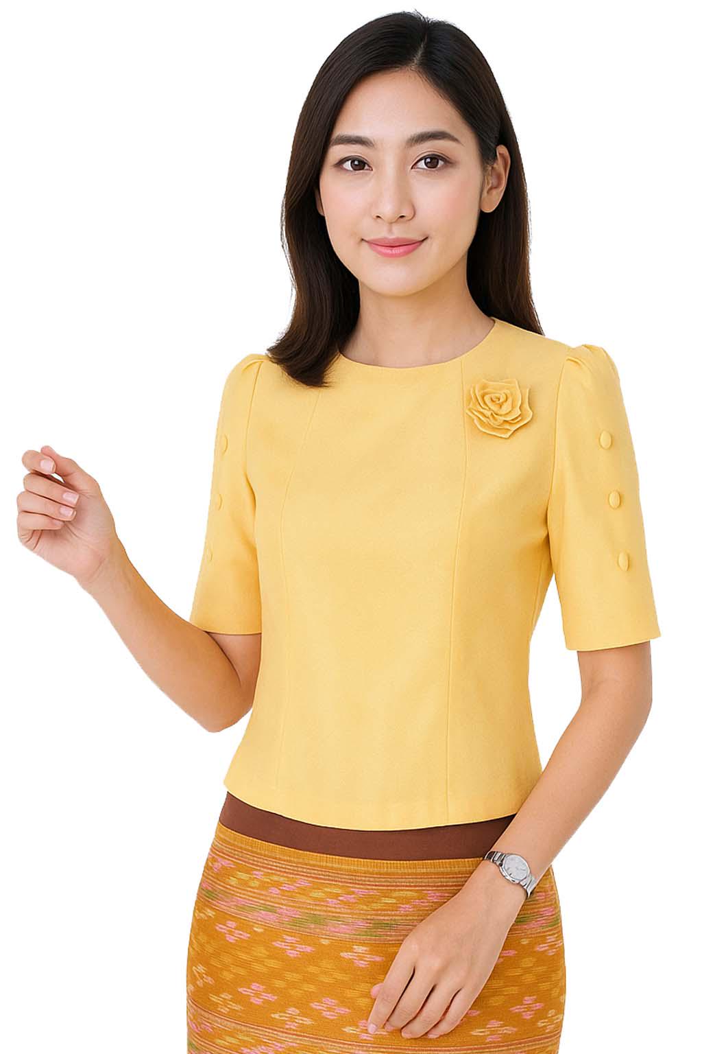 May include: A bright yellow short-sleeved blouse featuring a round neckline, a fabric rose embellishment on the left chest, and three matching buttons on each sleeve. The blouse is paired with a patterned skirt featuring horizontal bands of orange and brown.