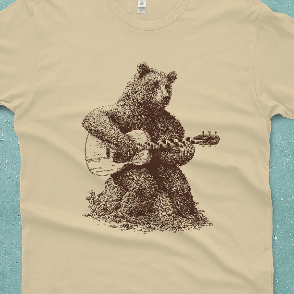 Cream T-shirt with a bear sitting on a log and playing an acoustic guitar.