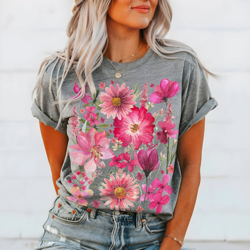 May include: Gray t-shirt featuring a vibrant floral design. The shirt showcases a bouquet of pink and magenta flowers, including daisies and tulips. The short-sleeved tee is made of a soft material.