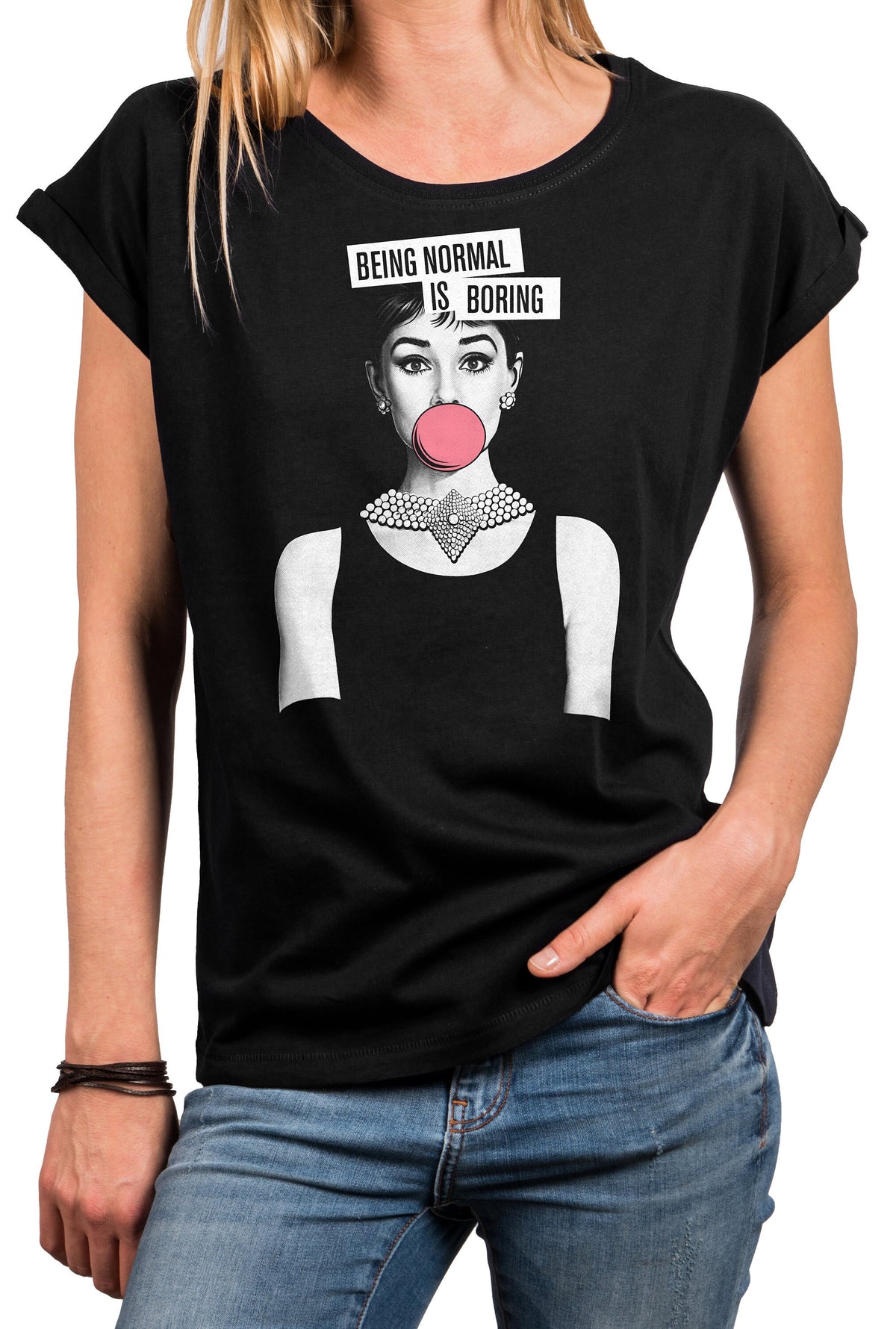 May include: Black t-shirt featuring a graphic of Audrey Hepburn blowing a bubblegum bubble, with the text "BEING NORMAL IS BORING" above her head. The shirt has a round neck and rolled-up sleeves.