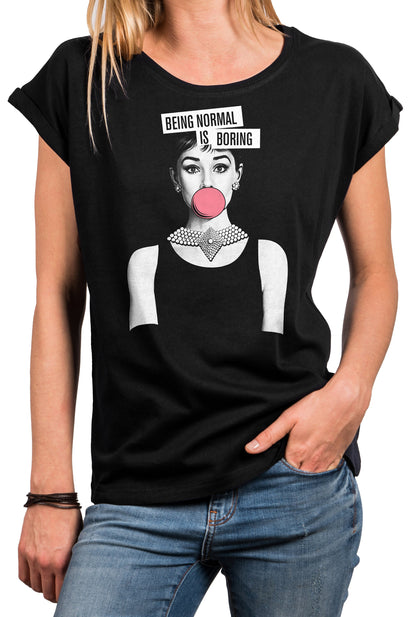 May include: Black t-shirt featuring a graphic of Audrey Hepburn blowing a bubblegum bubble, with the text "BEING NORMAL IS BORING" above her head. The shirt has a round neck and rolled-up sleeves.