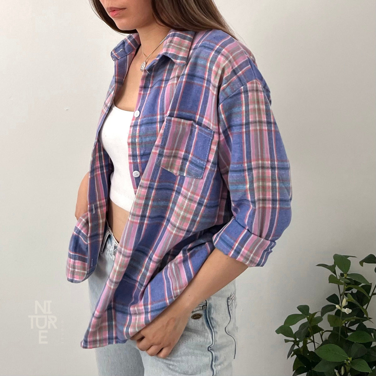 May include: A blue and pink plaid flannel shirt with long sleeves and a button-up front.