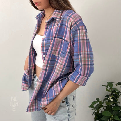 May include: A blue and pink plaid flannel shirt with long sleeves and a button-up front.