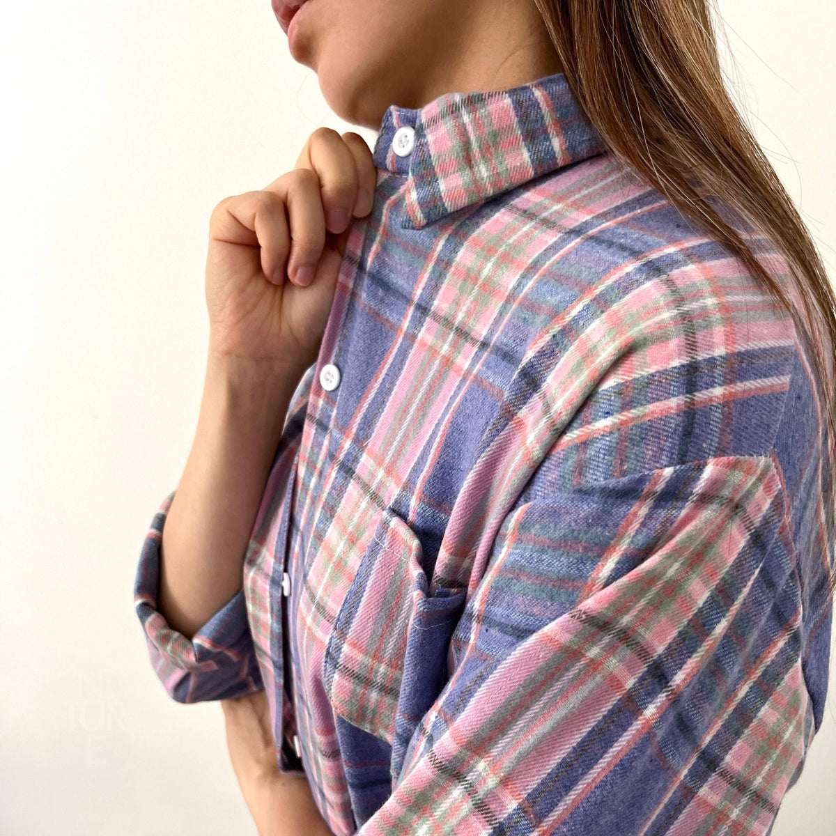 May include: A blue and pink plaid flannel shirt with a button-up collar.