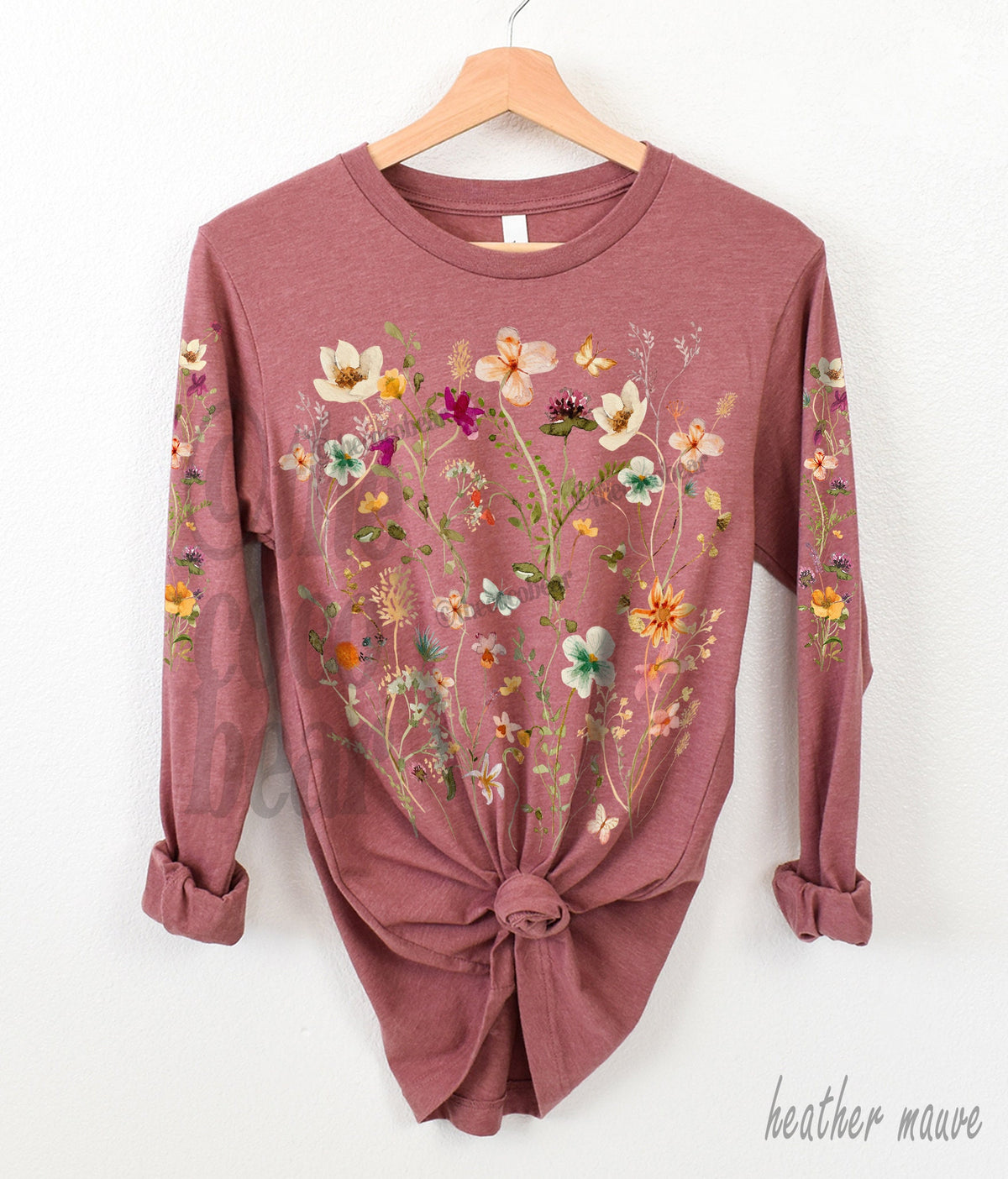 May include: A long-sleeved t-shirt with a floral print in shades of pink, yellow, and green. The shirt is heather mauve.