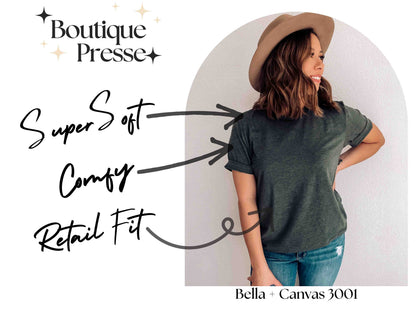 May include: A woman wearing a dark green t-shirt with the text "Bella + Canvas 3001" on the bottom. The t-shirt is described as "Super Soft", "Comfy", and "Retail Fit".