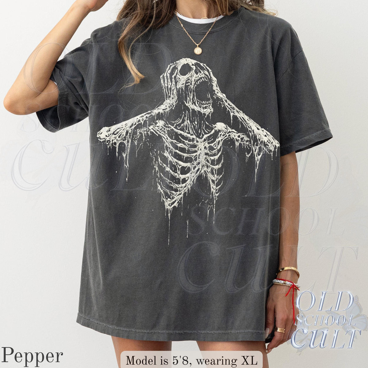May include: Dark grey t-shirt featuring a distressed white skeleton graphic. The shirt has short sleeves and a relaxed fit. The text "OLD SCHOOL CULT" is visible in the background. The model is 5'8" and wearing XL.