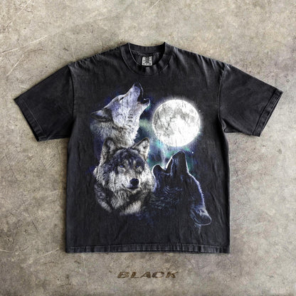 May include: Black t-shirt featuring a graphic of three wolves howling at a full moon. The design includes shades of gray, white, and blue. The word "BLACK" is printed at the bottom of the shirt.