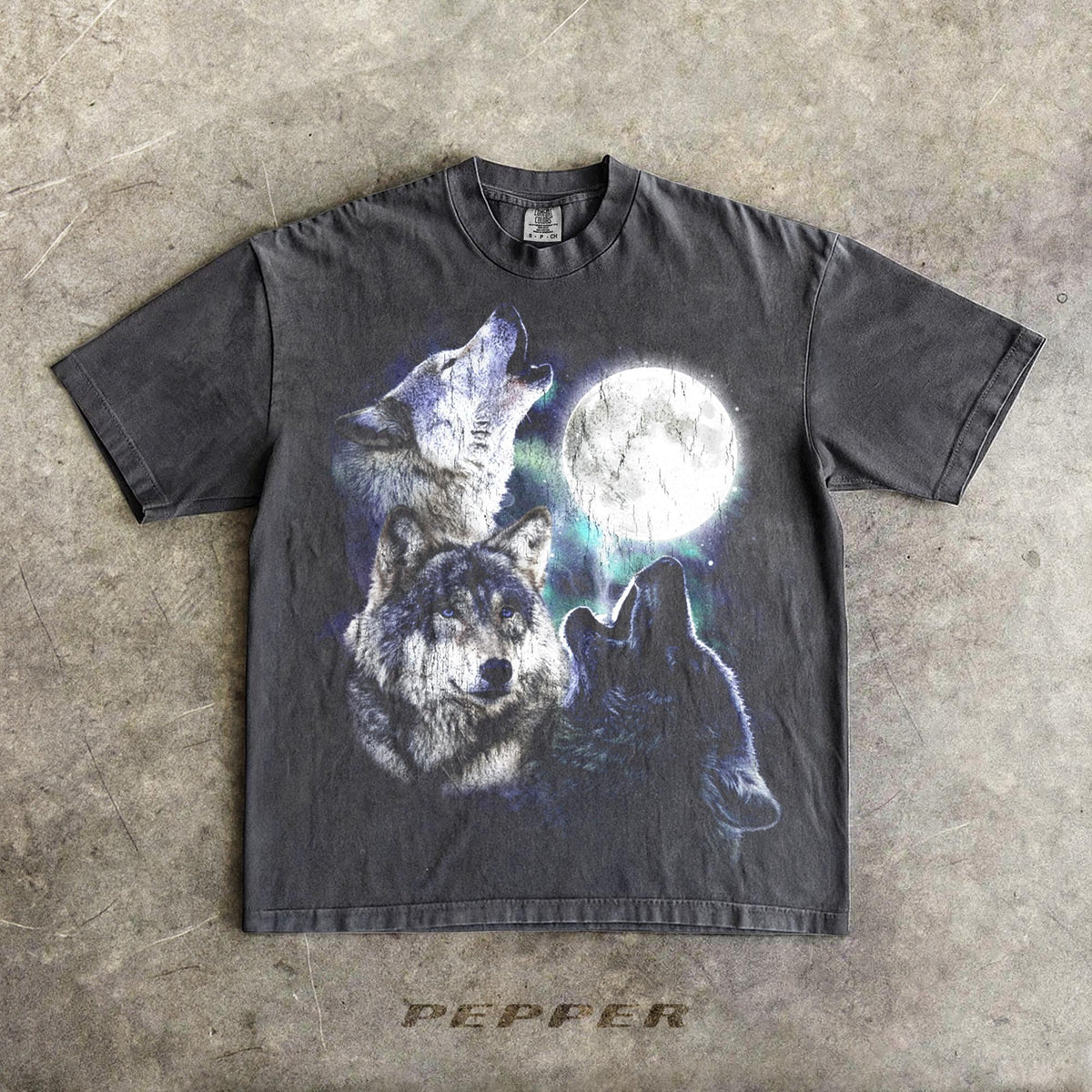 May include: Dark gray t-shirt featuring a graphic of three wolves howling at a full moon. The design includes shades of blue, white, and black. The word "PEPPER" is printed at the bottom of the shirt.