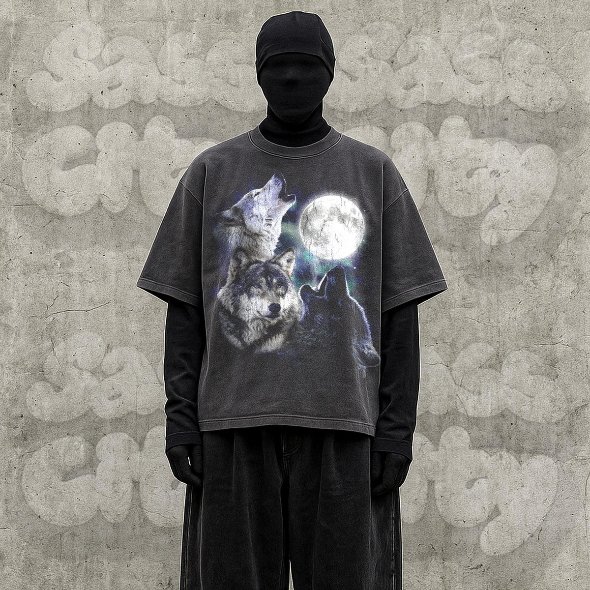 May include: Dark gray t-shirt featuring a graphic of three wolves howling at a full moon. The shirt has a vintage, distressed look. The model is wearing a black turtleneck and black pants.