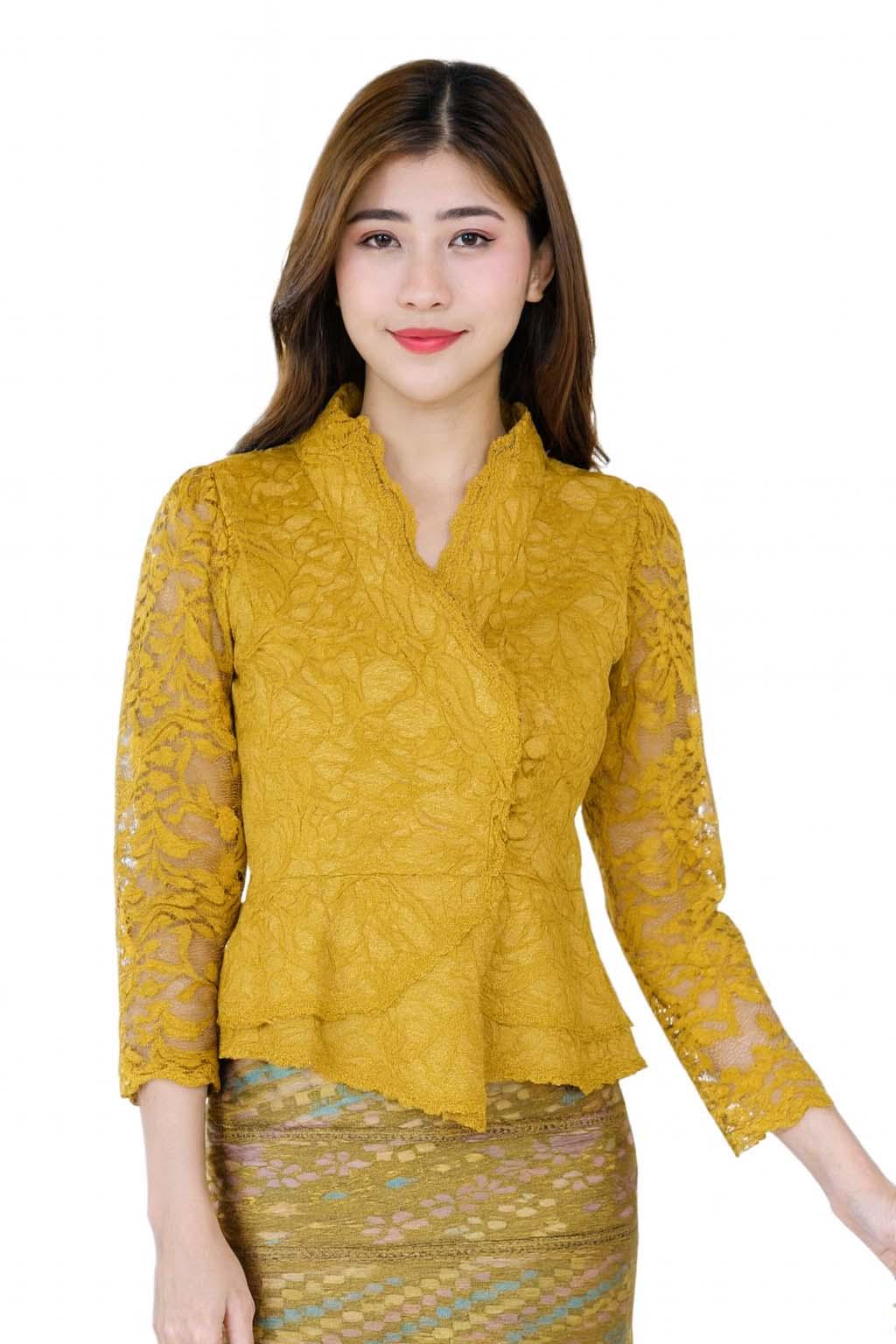 May include: Mustard yellow lace blouse with a V-neckline and three buttons. The blouse has long sleeves and a peplum hem. The model is wearing a patterned skirt. The blouse is made of a delicate lace fabric.