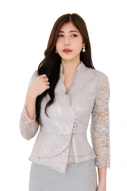 May include: A light gray lace blouse with a high collar and three-quarter sleeves. The blouse features a peplum design and is paired with a light blue patterned skirt. The outfit is suitable for formal occasions.