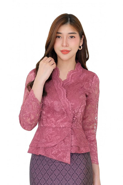 May include: A mauve-colored lace blouse with long sleeves and a wrap-style design. The blouse features a ruffled collar and a peplum hem. The fabric has a floral pattern. The blouse is paired with a patterned skirt.