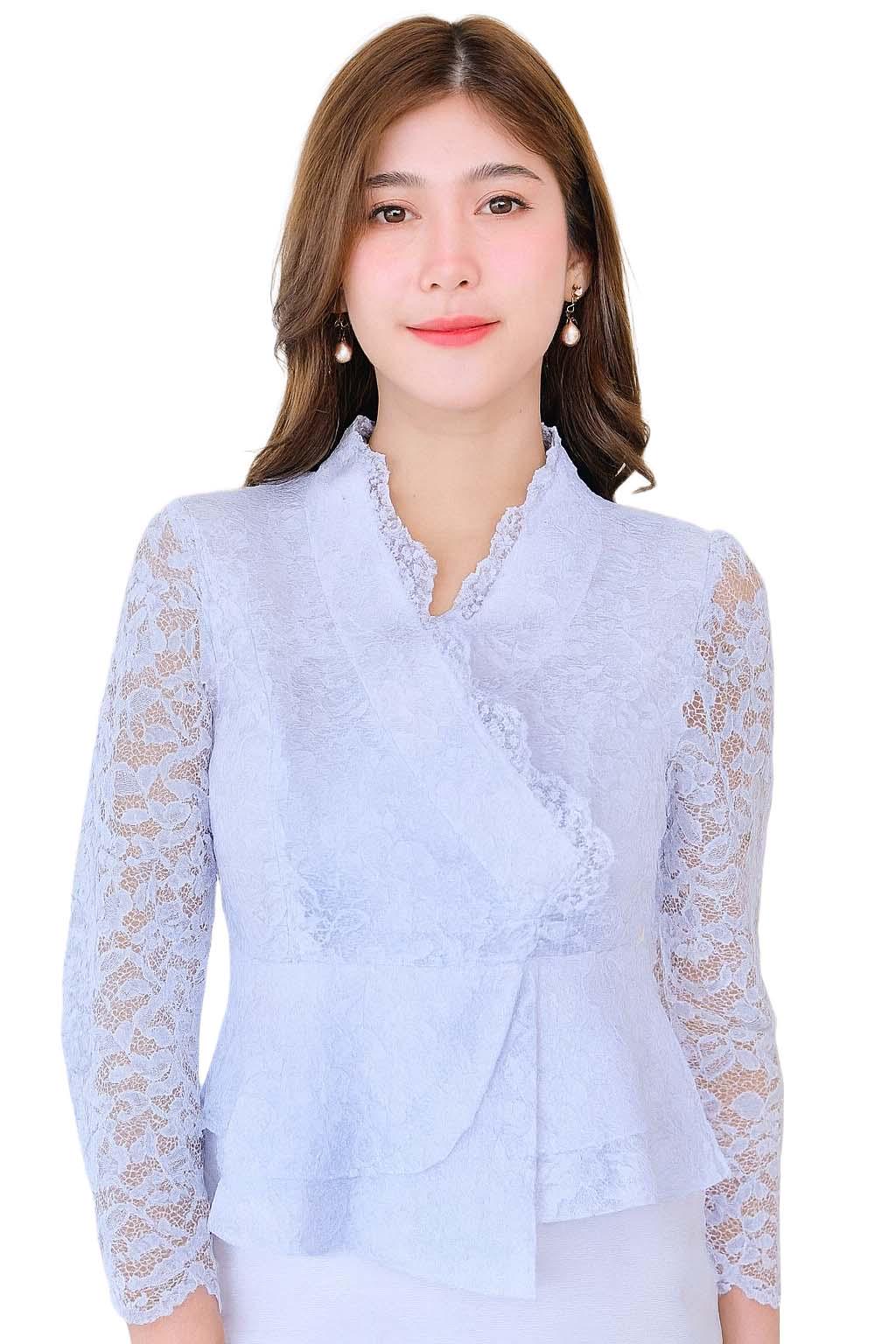 May include: A light blue lace blouse with long sleeves and a ruffled collar. The blouse has a wrap-style design and a peplum hem. The model is wearing pearl earrings.
