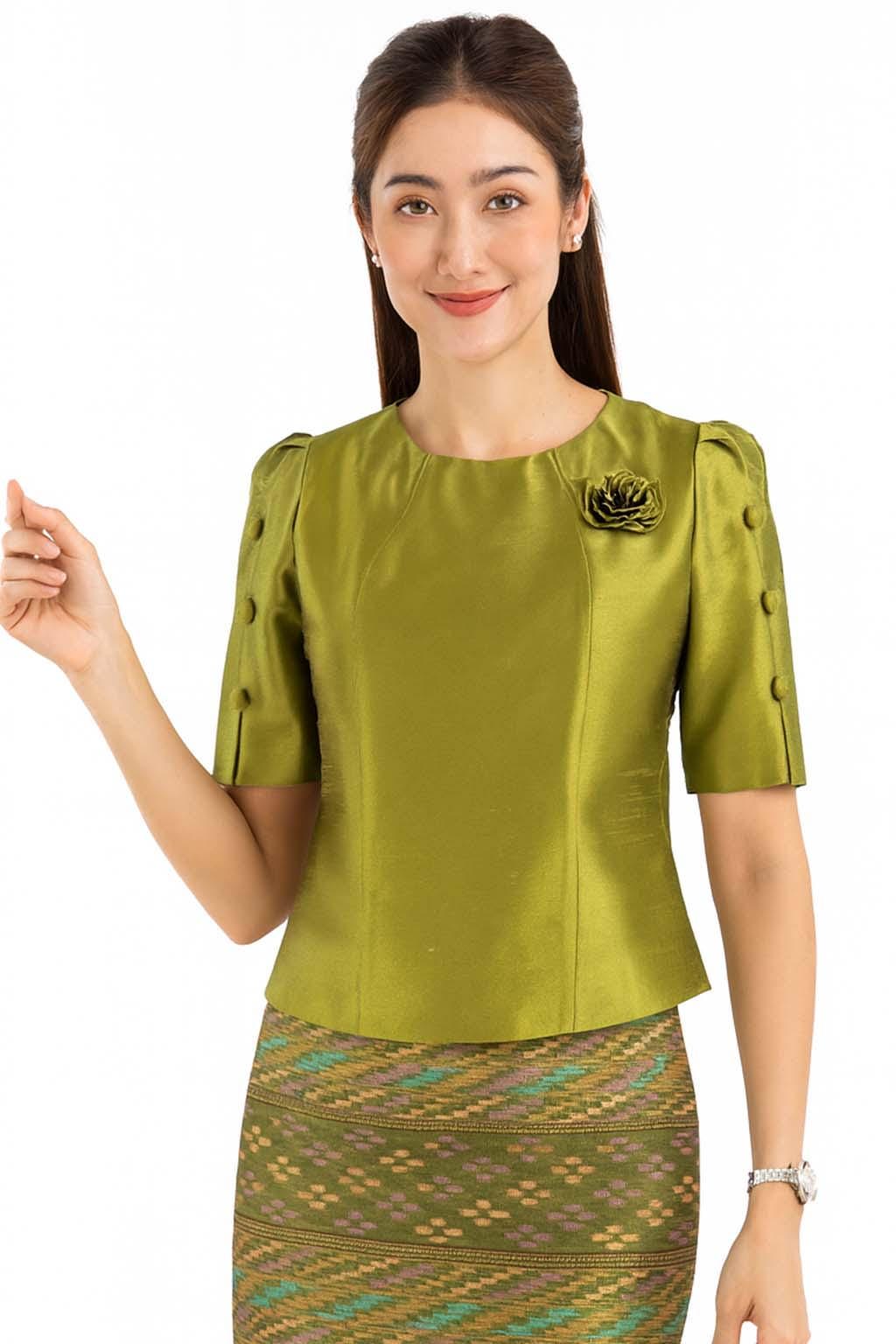 May include: A chartreuse green blouse with a round neckline, short sleeves featuring three decorative buttons on each side, and a matching fabric flower pinned to the left chest. The blouse is paired with a patterned skirt in shades of green and gold.