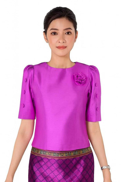 May include: A vibrant magenta blouse featuring a round neckline, short puff sleeves with three decorative buttons on each side, and a matching fabric flower accent on the left chest. The blouse is paired with a purple skirt with a patterned waistband.