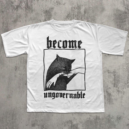 May include: White t-shirt with a black graphic of a cat biting a hand, framed within a black rectangle. The words "become" and "ungovernable" are printed above and below the graphic in a gothic font.