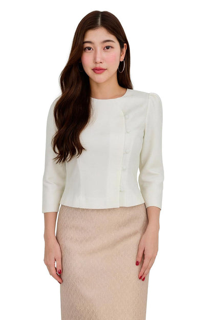 May include: Cream-colored blouse with three-quarter sleeves and a row of buttons on the side. The blouse is paired with a beige skirt. The outfit is suitable for formal or business attire.
