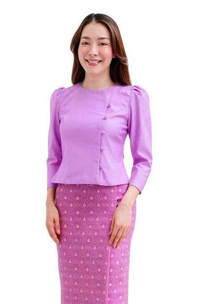 May include: A lilac-colored blouse with three-quarter sleeves and a matching skirt. The blouse features a buttoned front and a round neckline. The skirt has a repeating geometric pattern in shades of pink and purple.