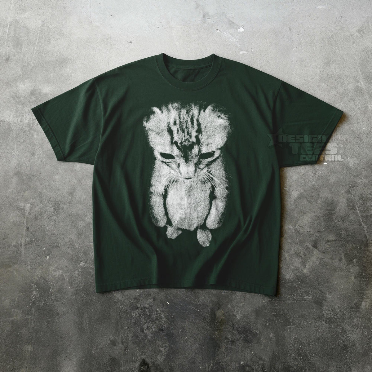 May include: Dark green t-shirt featuring a distressed, grayscale image of a sad-looking kitten. The graphic is centered on the shirt. The text "DESIGN TEES CENTRAL" is visible on the right side of the shirt.