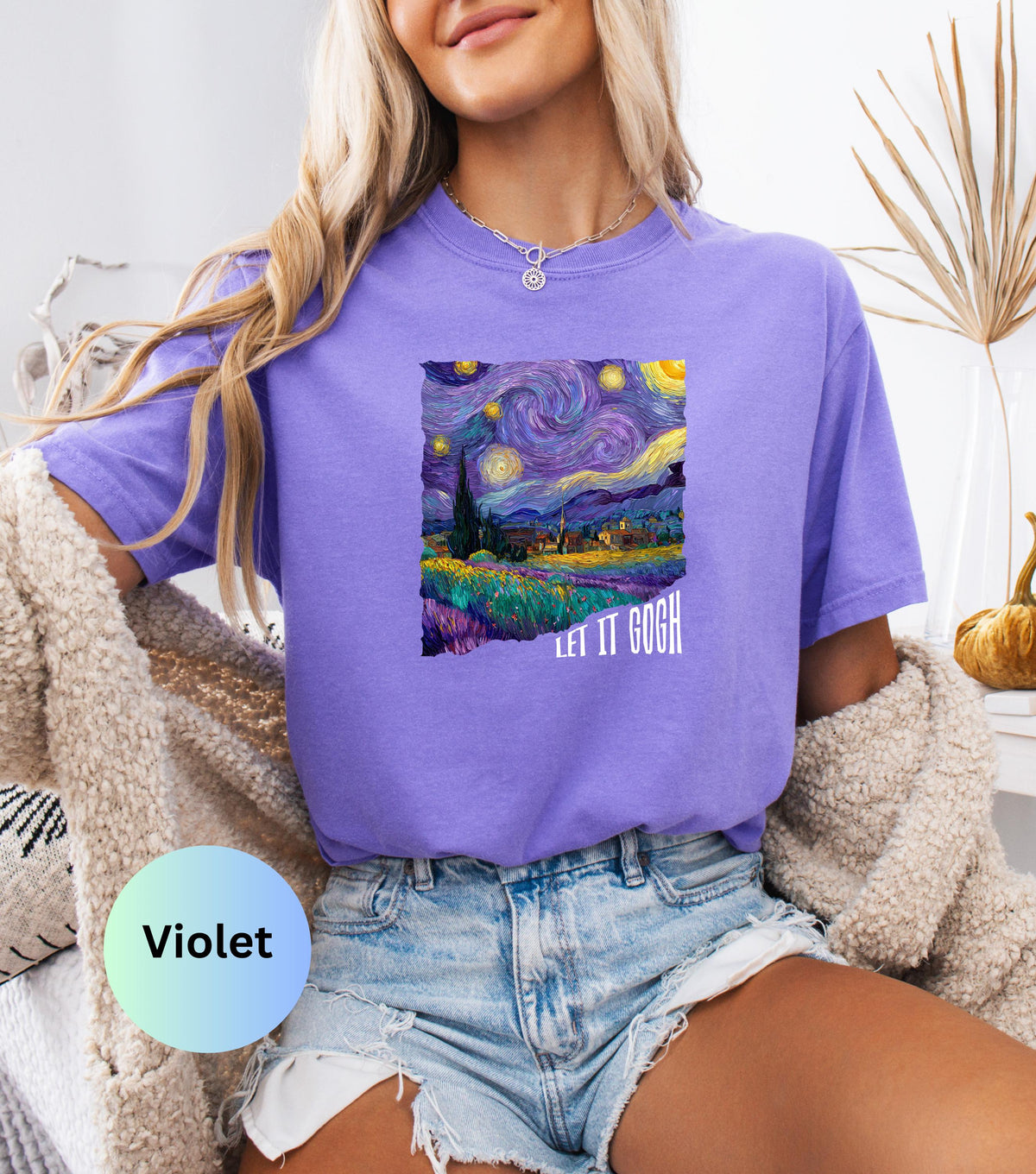 May include: Violet-colored t-shirt featuring a print of Van Gogh's "Starry Night" painting. The artwork includes a swirling night sky, a village, and the text "LET IT GOGH". The shirt is paired with denim shorts.
