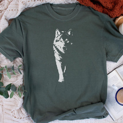 May include: A dark green t-shirt featuring a white graphic of a wolf. The wolf is depicted in a detailed, stylized manner, with its fur and features clearly visible. The shirt has a classic crew neck and short sleeves.