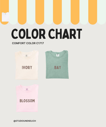 May include: Color chart featuring three folded t-shirts in ivory, bay, and blossom colors. The text "COLOR CHART" and "COMFORT COLOR C1717" are displayed above the shirts. The brand's social media handle is at the bottom.