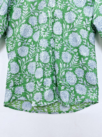 May include: Green button-down shirt with a white and blue floral pattern. The shirt features a repeating design of large flowers and leaves. The fabric has a slightly textured appearance.