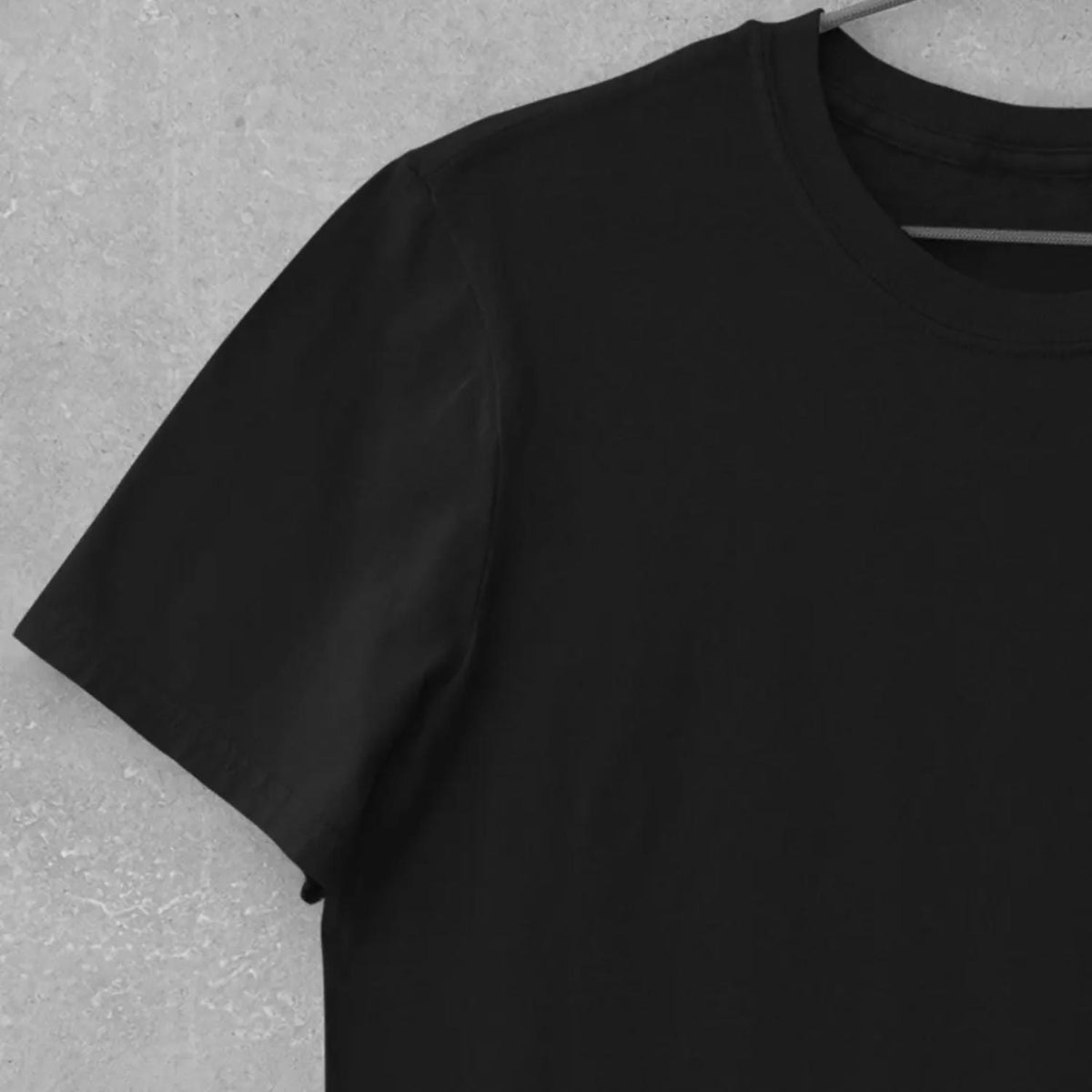 May include: A solid black short-sleeved t-shirt featuring a classic crew neckline. The garment is displayed on a hanger, showcasing the smooth fabric texture and the clean, minimalist construction of the sleeve and shoulder seams.