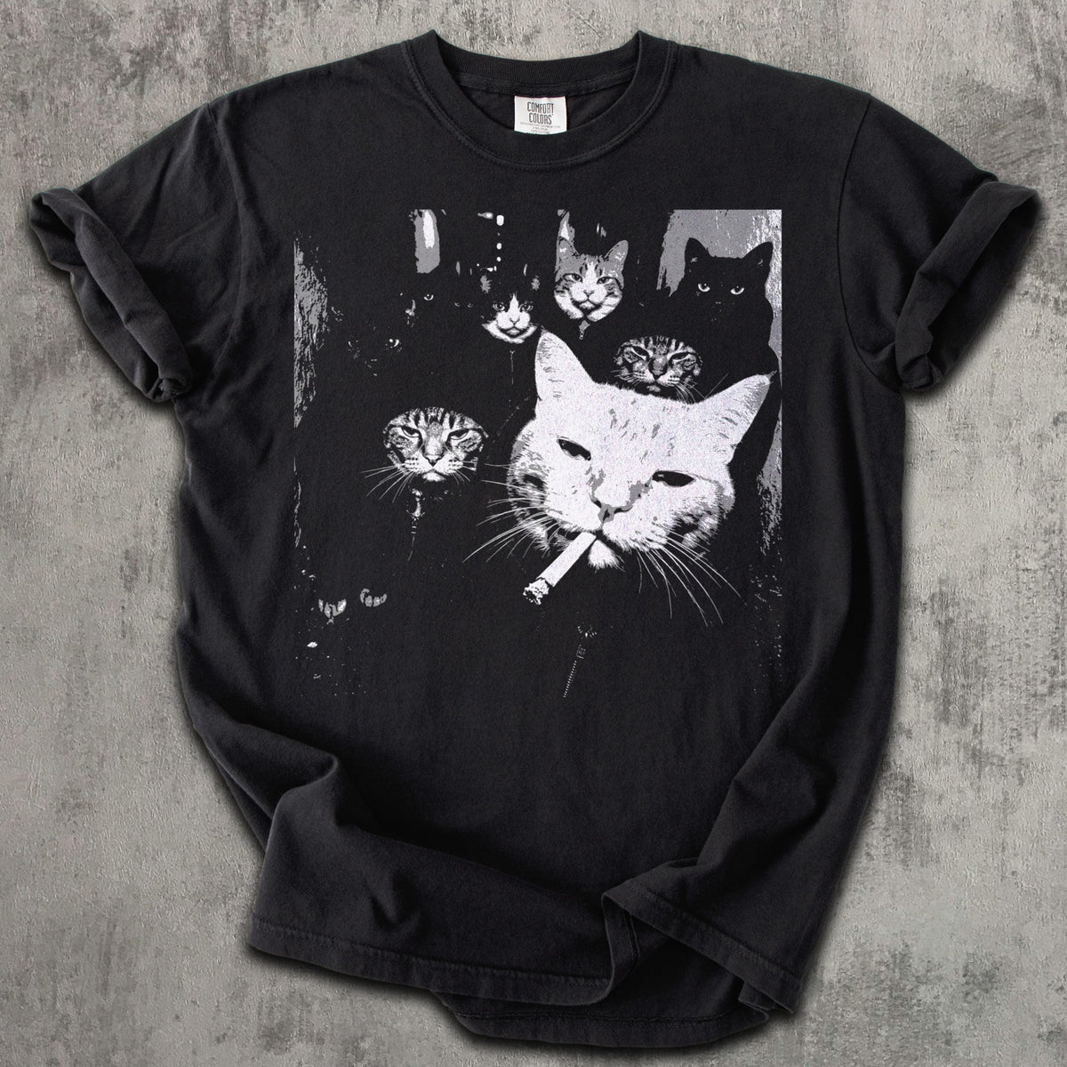 May include: Black t-shirt featuring a black and white graphic of several cats. One large cat in the foreground is smoking a cigarette. The other cats are in the background.