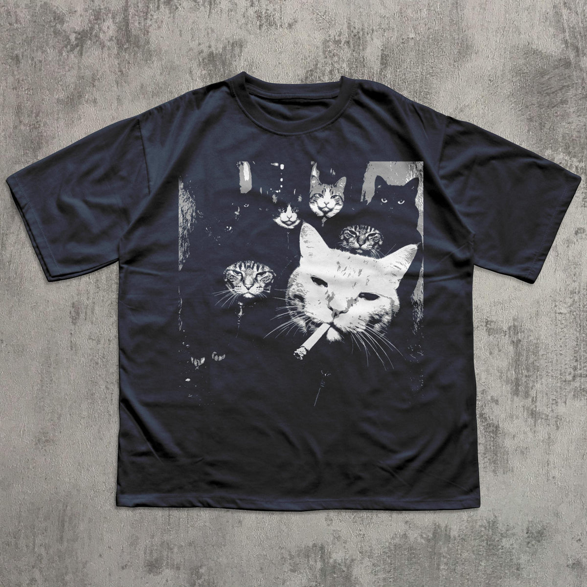 May include: Dark navy blue t-shirt featuring a black and white graphic of several cat faces, with one cat smoking a cigarette. The design has a vintage, slightly distressed look, with a grunge aesthetic.