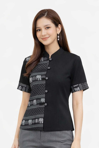 May include: Black short-sleeved blouse with a mandarin collar and decorative buttons. The left side features a patterned design with elephants in gray and white. The sleeves also have a matching patterned trim. The blouse is paired with gray pants.