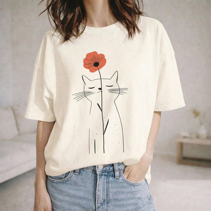 May include: An off-white short-sleeve t-shirt featuring a black line art illustration of a cat with closed eyes. The cat is holding a single orange-red poppy flower on a thin stem that extends vertically between its ears.