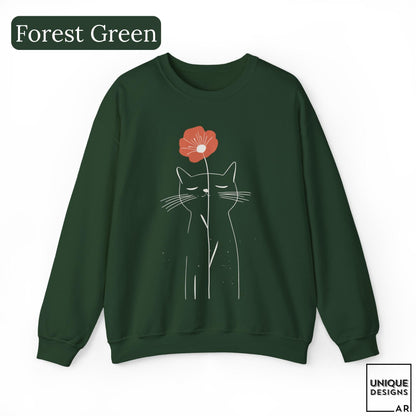 May include: A forest green crewneck sweatshirt featuring a white line art illustration of a cat with closed eyes. A single orange flower is positioned above the cat's head. The text Forest Green appears in the top left corner and Unique Designs AR in the bottom right.