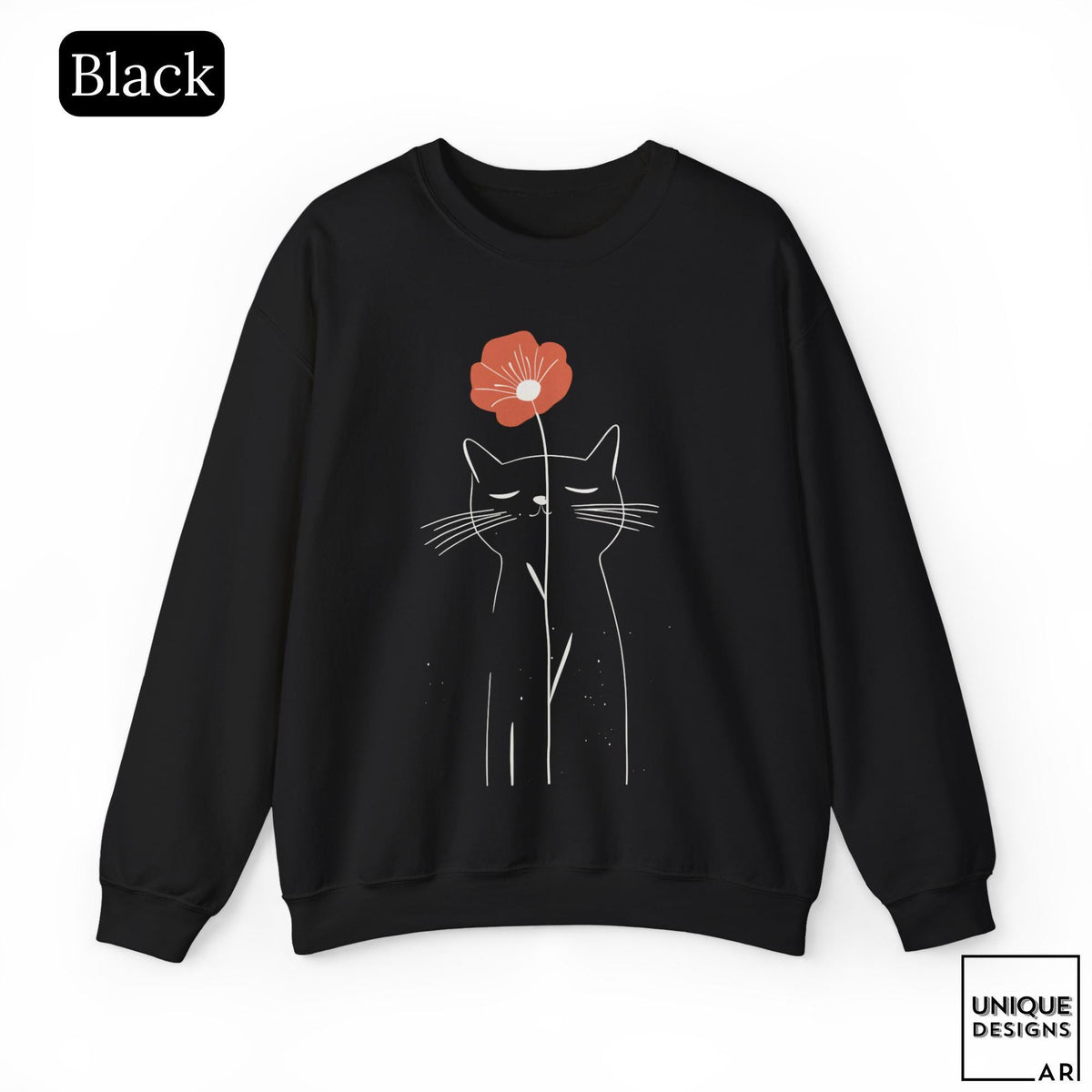 May include: A black long-sleeve sweatshirt featuring a white line art illustration of a cat with closed eyes. A single orange-red flower is positioned above the cat's head, with its stem extending downward. The text Black appears in the top left corner.