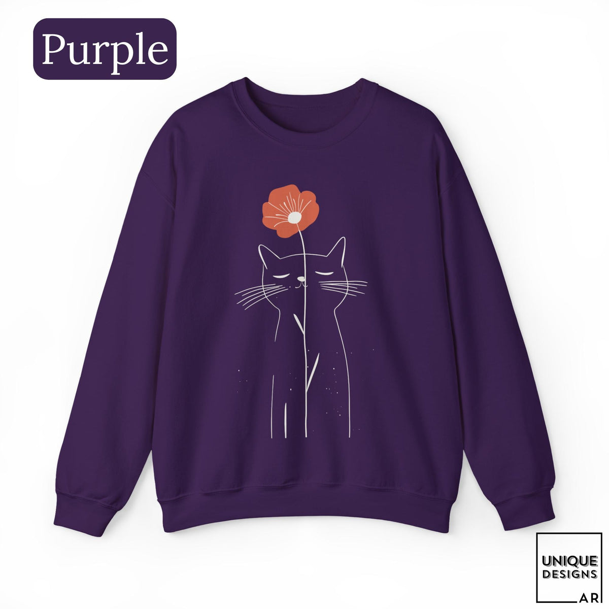 May include: A purple long-sleeve sweatshirt featuring a white line art illustration of a cat with closed eyes. A single orange flower is positioned above the cat's head. The text "Purple" appears in the top left corner and "UNIQUE DESIGNS" in the bottom right.