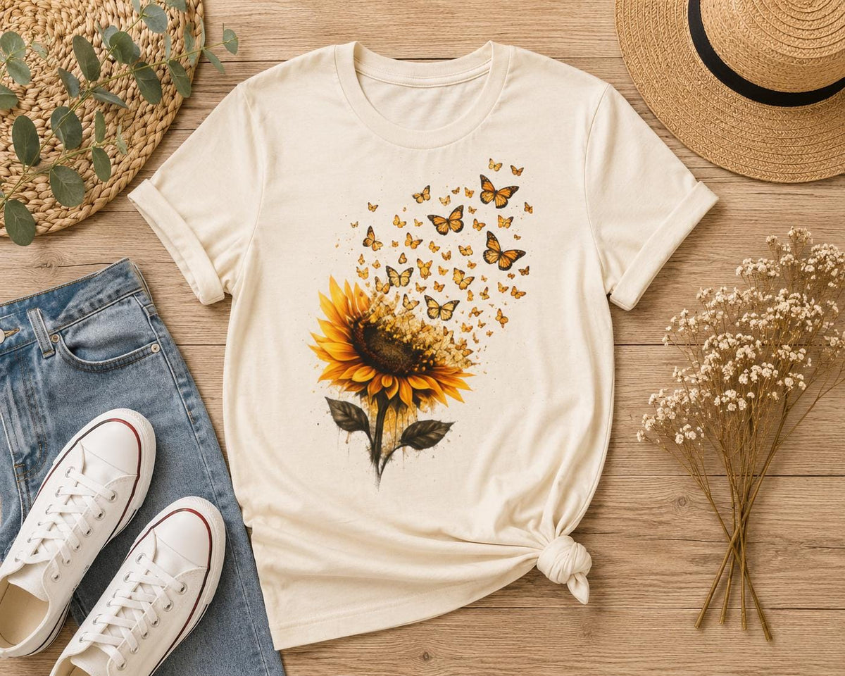 Sunflower butterfly t-shirt in natural color displayed in a flat lay on a wooden background with jeans, white sneakers, straw hat and dried flowers.Sonnenblumen-Schmetterlings-T-Shirt in Naturfarbe als Flatlay auf Holzuntergrund mit Jeans, weißen Sneakers, Strohhut und Trockenblumen.