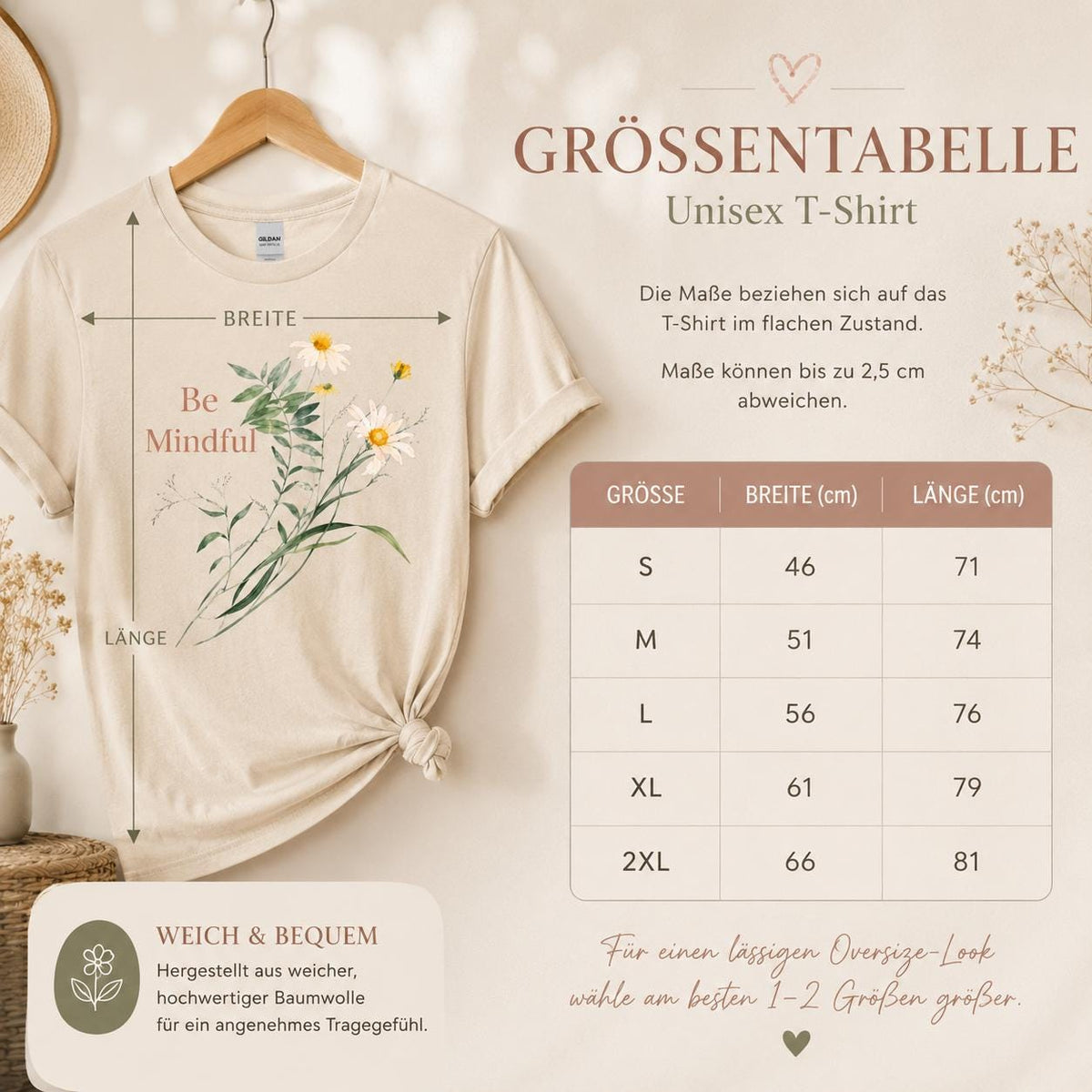 May include: A beige short-sleeved t-shirt featuring a graphic of white daisies and green foliage with the text Be Mindful. A size chart displays measurements in centimeters for sizes S through 2XL, indicating widths from 46 to 66 cm and lengths from 71 to 81 cm.