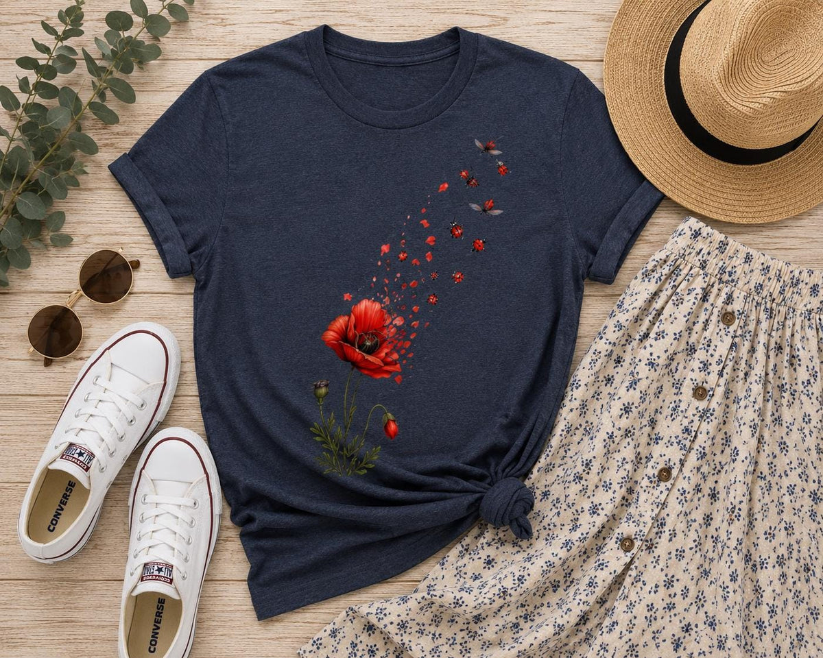 May include: A dark navy blue short-sleeve t-shirt featuring a graphic print of a red poppy flower that appears to be disintegrating into small red petals and flying ladybugs. The shirt has a crew neckline and a straight hemline.