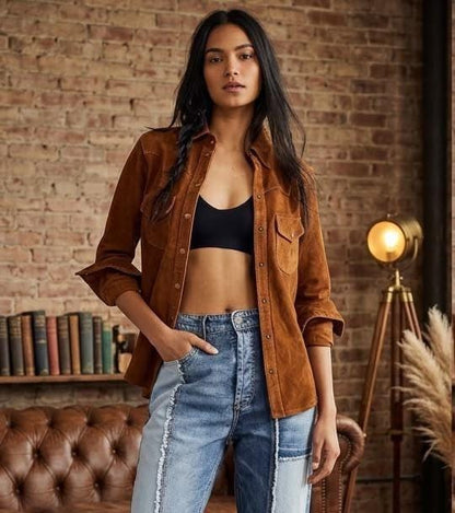 May include: A brown suede button-down shirt worn open over a black crop top, paired with blue denim jeans featuring a vertical light-wash panel down the front of each leg with raw, frayed edges along the seams and a high-waisted fit.