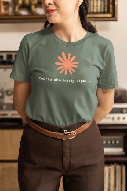 May include: A sage green short-sleeved t-shirt featuring a coral-colored flower graphic centered above the white text that reads, "You're absolutely right -" in a simple, clean font. The shirt has a crew neckline and a standard fit.