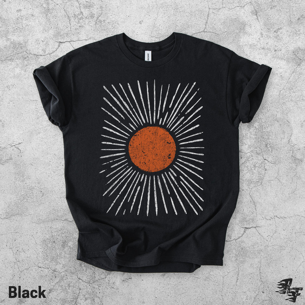 May include: A black short-sleeve t-shirt featuring a central graphic of a distressed orange circle surrounded by radiating white lines. The design has a textured, weathered appearance, and the shirt has a standard crew neckline and short sleeves.