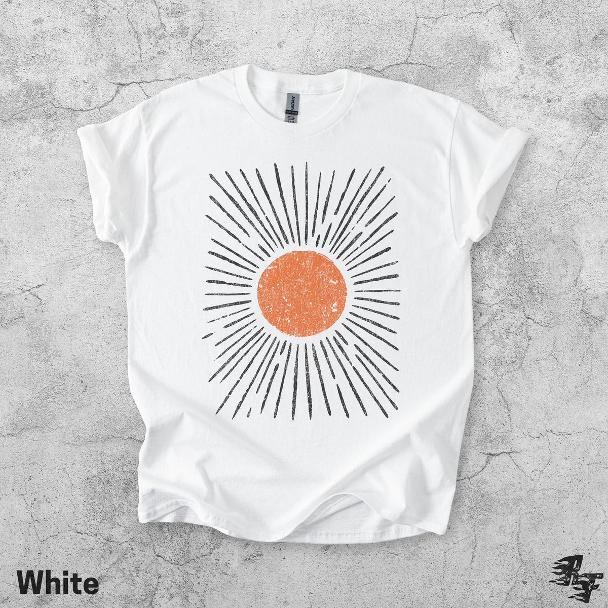 May include: A white short-sleeved t-shirt featuring a central graphic of a distressed orange circle surrounded by radiating black lines. The design has a textured, weathered appearance. The shirt has a crew neckline and a standard fit.
