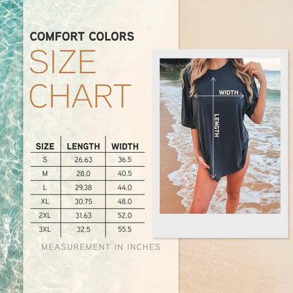 May include: A Comfort Colors size chart featuring a table with length and width measurements in inches for sizes S through 3XL. The chart includes a photograph of a dark gray t-shirt with arrows indicating the length and width dimensions.