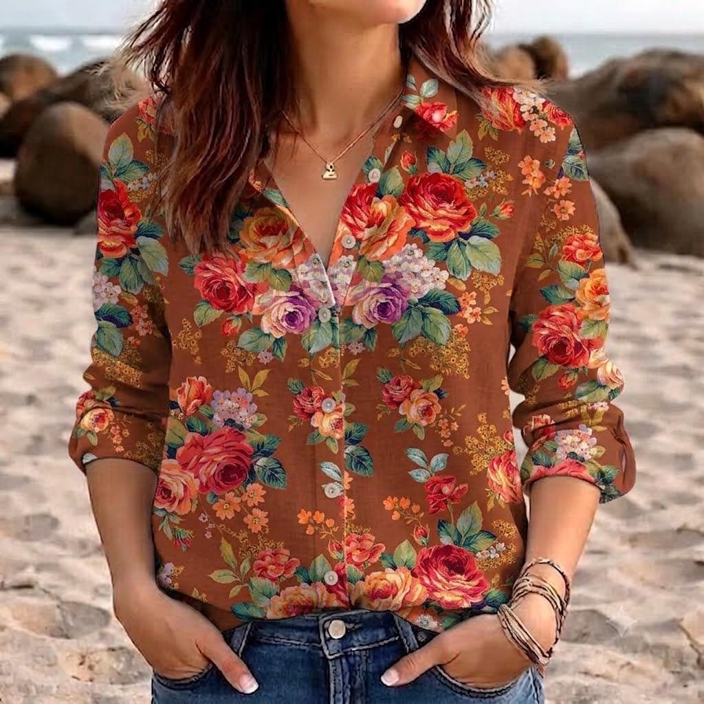 May include: A long-sleeved button-down shirt in a warm brown hue, featuring a vibrant floral pattern with red, orange, yellow, and purple roses, green leaves, and small white blossoms. The shirt has a classic collar and a front button closure.