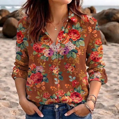 May include: A long-sleeved button-down shirt in a warm brown hue, featuring a vibrant floral pattern with red, orange, yellow, and purple roses, green leaves, and small white blossoms. The shirt has a classic collar and a front button closure.