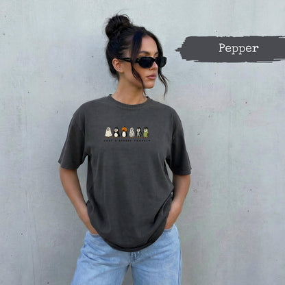 Dark grey t-shirt with "JUST A SPOOKY PENGUIN" and Halloween penguins graphic.