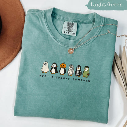 Light green t-shirt with "Just a Spooky Penguin" and cartoon penguins.