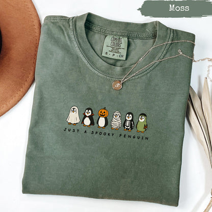 Moss colored t-shirt with "Just a Spooky Penguin" and Halloween penguins graphic.